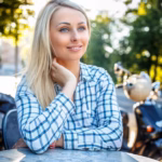 smiling-girl-with-long-blond-hair-t-shirt-sitting-table-outside_613910-15456
