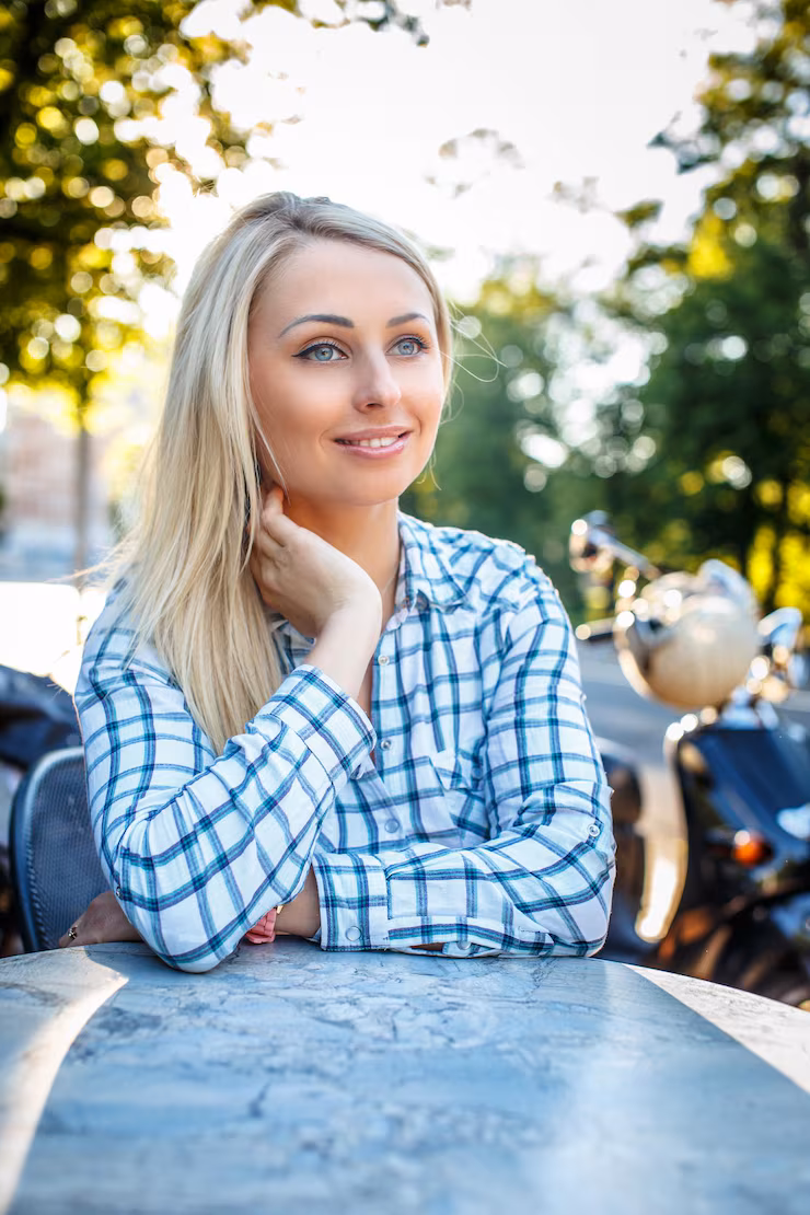 smiling-girl-with-long-blond-hair-t-shirt-sitting-table-outside_613910-15456