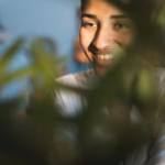 smiling-woman-portrait-with-blurred-plant_23-2148304879